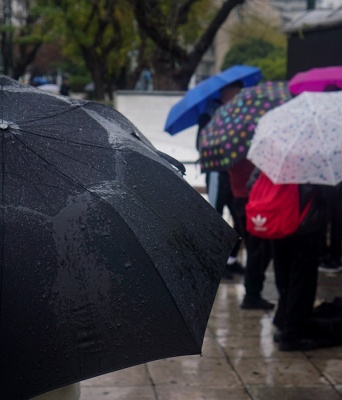 Πολίτες με ομπρέλες προστατεύονται από τη βροχή