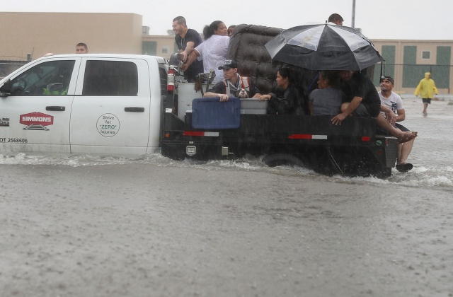 Άνθρωποι χρησιμοποιούν ένα φορτηγάκι για να εκκενώσουν τα σπίτια τους μετά την πλημμύρα της περιοχής