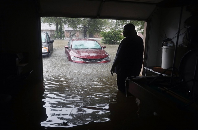 Ένας άνθρωπος περιμένει να σωθεί από το πλημμυρισμένο σπίτι του