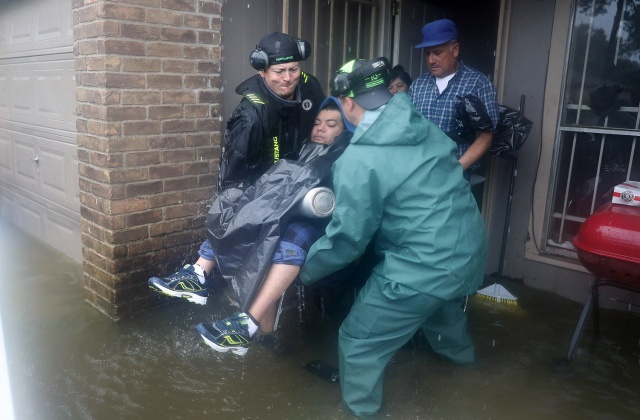 Κάτοικοι της περιοχής απεγκλωβίζουν έναν άνθρωπο απο το πλημμυρισμένο του σπίτι