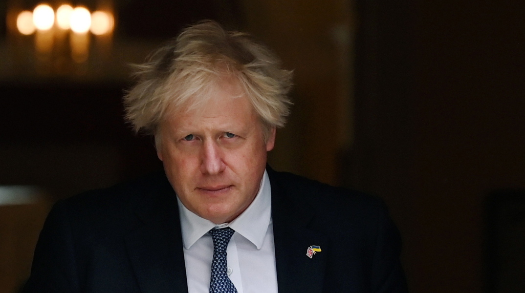 Ο πρωθυπουργός της Βρετανίας, Μπόρις Τζόνσον κρατά φάκελο και βγαίνει από αίθουσα