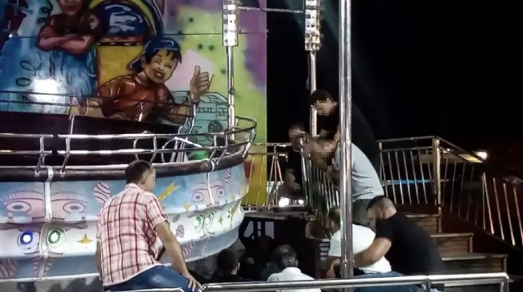 Άνδρες κοιτούν τον μηχανισμό παιχνιδιού σε λούνα παρκ στον Αλμυρό Βόλου όπου έχασε τη ζωή της 14χρονη