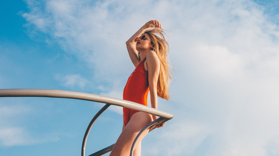 Ξανθιά κοπέλα, με κόκκινο μαγιό, πάνω σε σκάφος