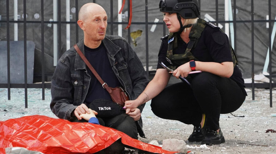 Ο πατέρας στην Ουκρανία που κρατά το χέρι του νεκρού γιου του στη μέση του δρόμου