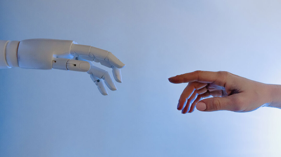 Ανθρώπινο και ρομποτικό χέρι που ακουμπιούνται