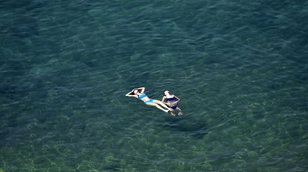 Λουόμενες στην παραλία απολαμβάνουν τη θάλασσα