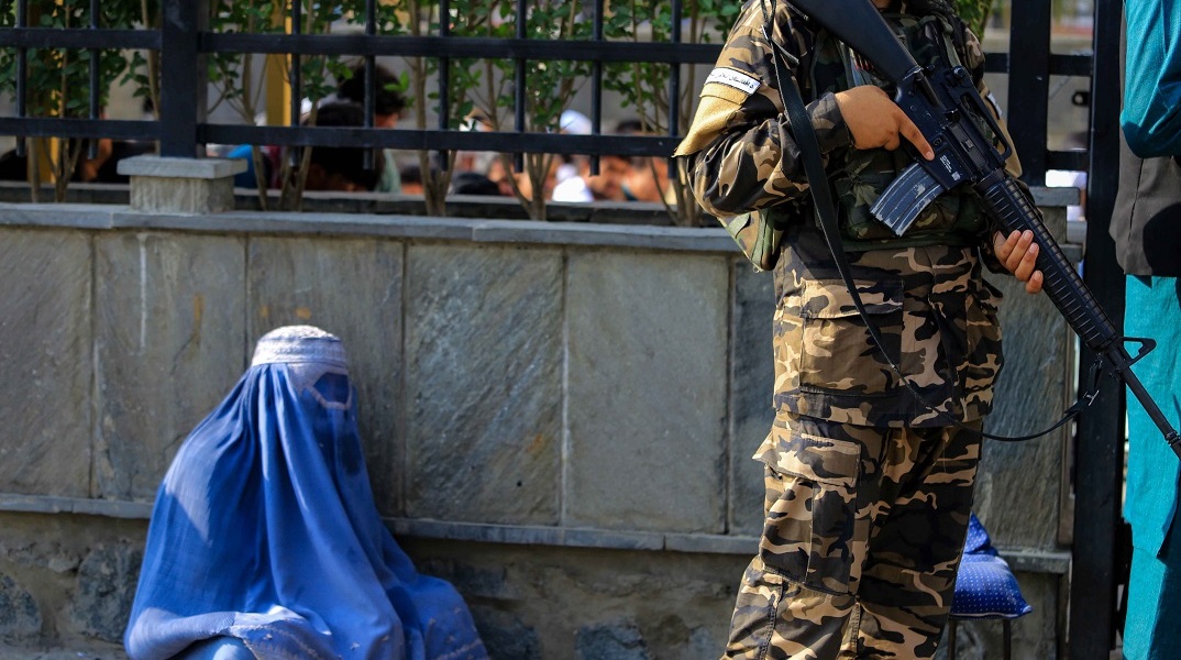 Γυναίκα με μπούρκα στο Αφγανιστάν δίπλα σε ένοπλο Ταλιμπάν στην πρωτεύουσα Καμπούλ