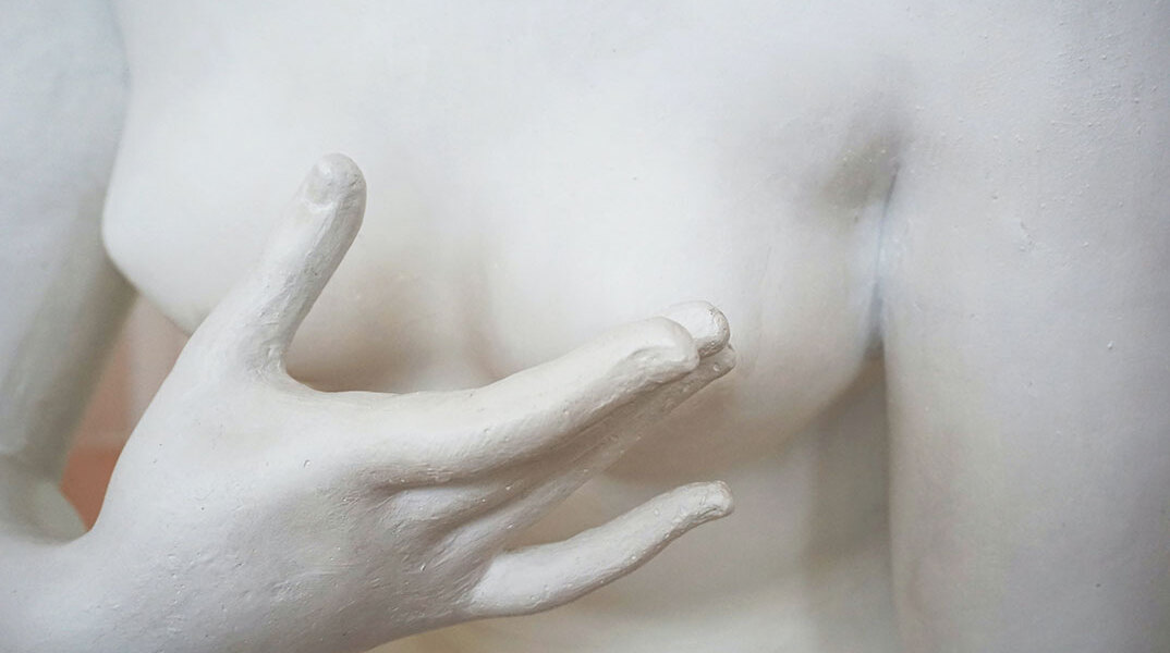 Γυναίκειο άγαλμα που αγγίζει το στήθος του