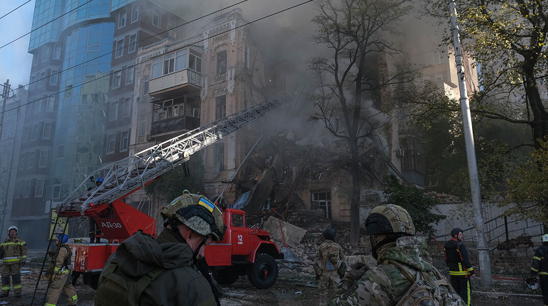 Διασώστες μπροστά σε βομβαρδισμένη πολυκατοικία στο Κίεβο μετά τη ρωσική επίθεση με drone