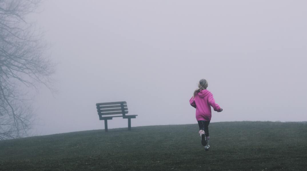 Μικρό κορίτσι που τρέχει μέσα στην ομίχλη
