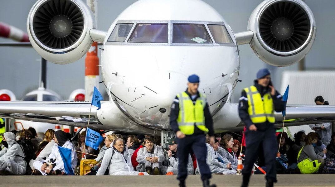 Ακτιβιστές στο Άμστερνταμ κάθονται μπροστά στις ρόδες ιδιωτικών τζετ στο αεροδρόμιο Σίπχολ