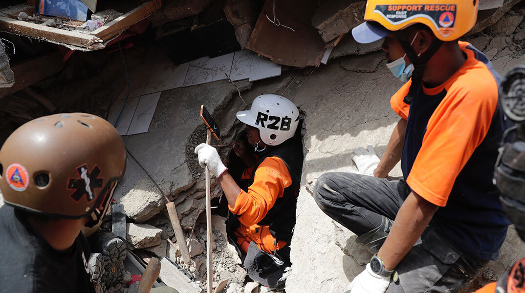 Διασώστης στην Ινδονησία μπαίνει σε κατεστραμμένο κτίριο, αναζητώντας επιζώντες μετά τον σεισμό