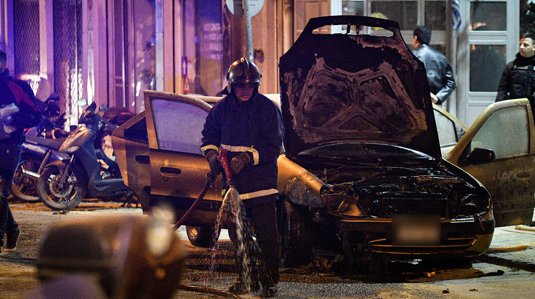 Πυροσβέστης σβήνει φωτιά σε αυτοκίνητο έξω από το ΑΤ Ακροπόλεως μετά από επίθεση με μολότοφ