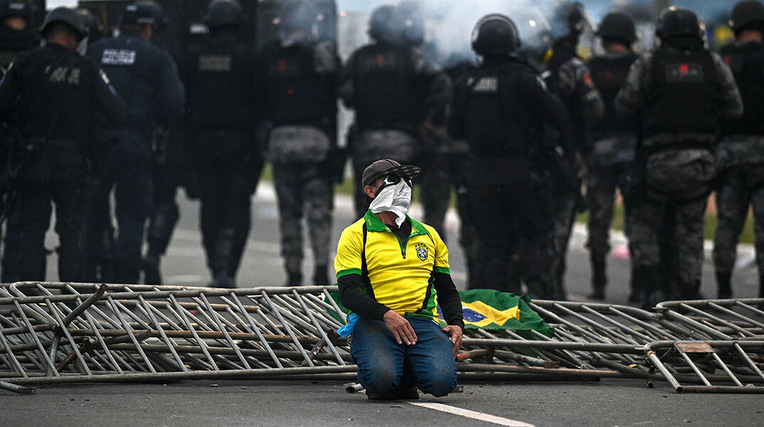 Υποστηρικτής του Μπολσονάρου ανάμεσα σε αστυνομικούς μετά την εισβολή στο Κογκρέσο στην πρωτεύουσα της Βραζιλίας