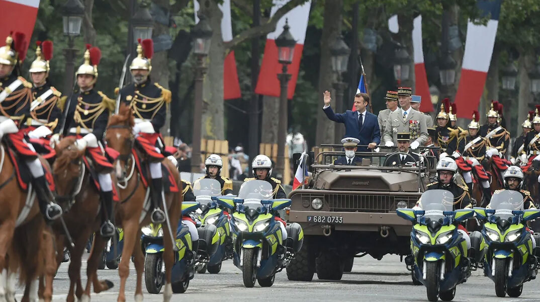 Ο Εμανουέλ Μακρόν πάνω σε στρατιωτικό τζιπ κατά τη διάρκεια παρέλασης στο Παρίσι