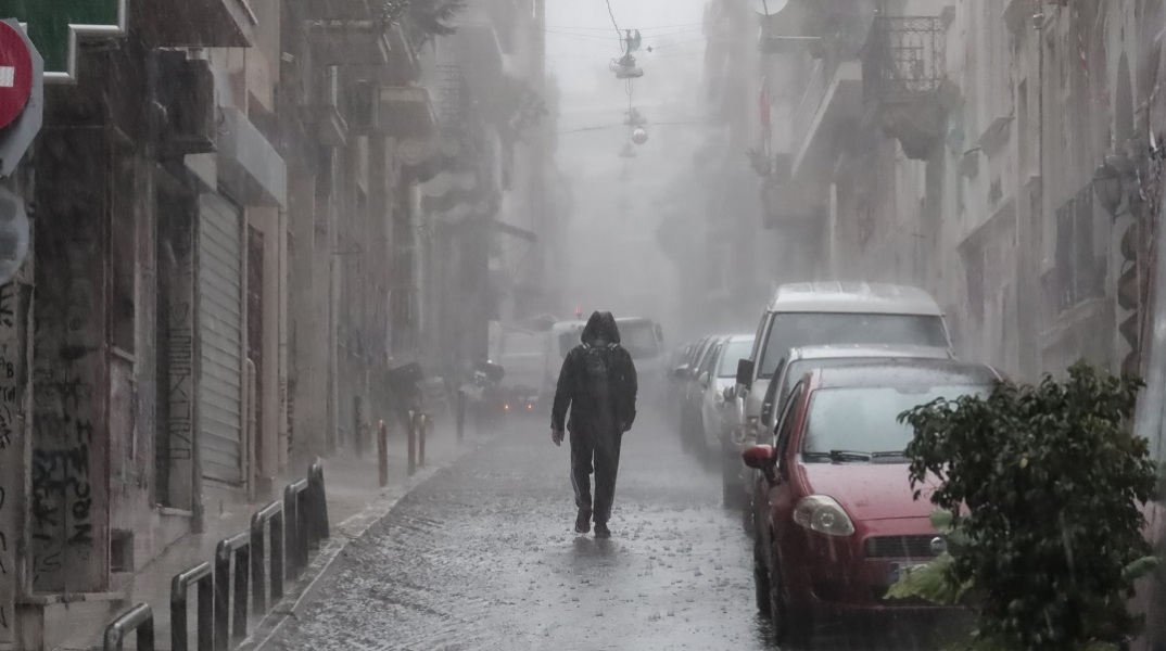 Κακοκαιρία: Πολίτες μέσα στη βροχή και σε πλυμμυρισμένο δρόμο