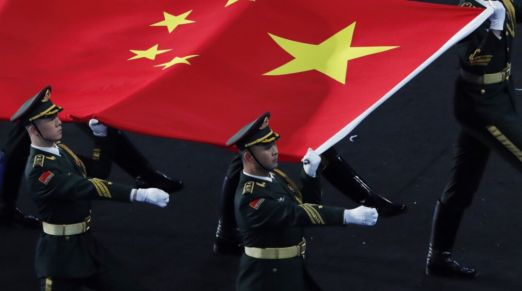 Κινέζοι στρατιώτες μεταφέρουν τη σημαία της Κίνας