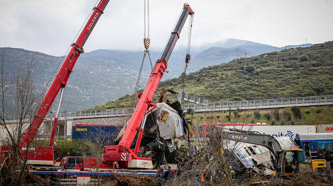 Γερανοί απομακρύνουν τα κατεστραμμένα βαγόνια μετά τη σύγκρουση τρένων στα Τέμπη