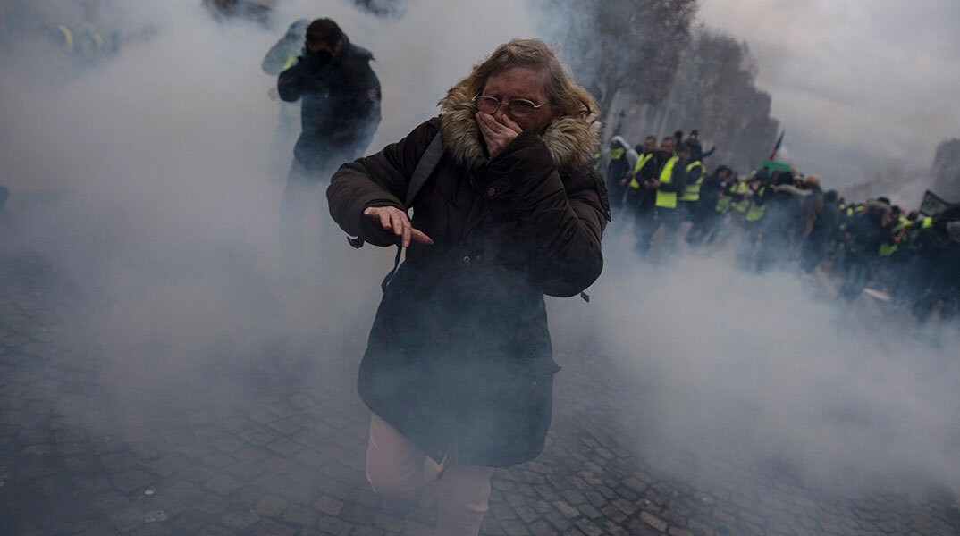 Γυναίκα σε διαδήλωση στο Παρίσι δυσκολεύεται να αναπνεύσει από τα δακρυγόνα
