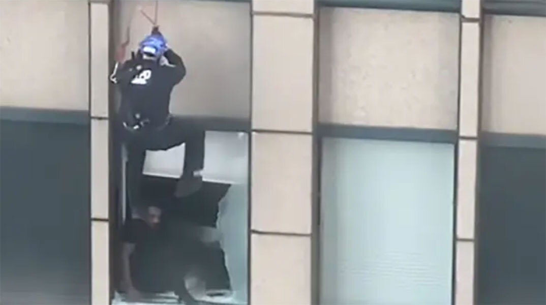Στιγμιότυπο από την επιχείρηση διάσωσης άνδρα που απειλούσε να πέσει από τον 31ο όροφο ουρανοξύστη στη Νέα Υόρκη