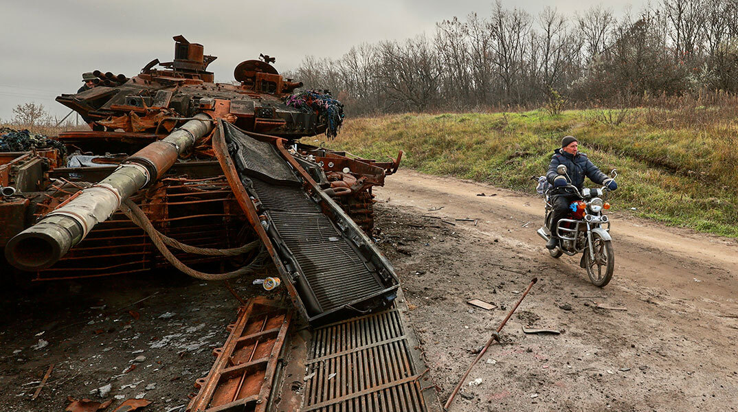 Κάτοικος στο Χάρκοβο περνά με τη μηχανή δίπλα από κατεστραμμένο ρωσικό τανκ
