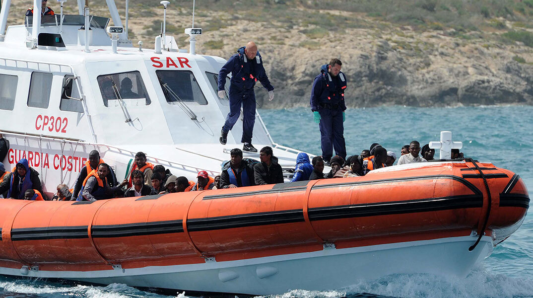 Σκάφος της ιταλικής Ακτοφυλακής μπροστά σε φουσκωτό με μετανάστες από την Αφρική