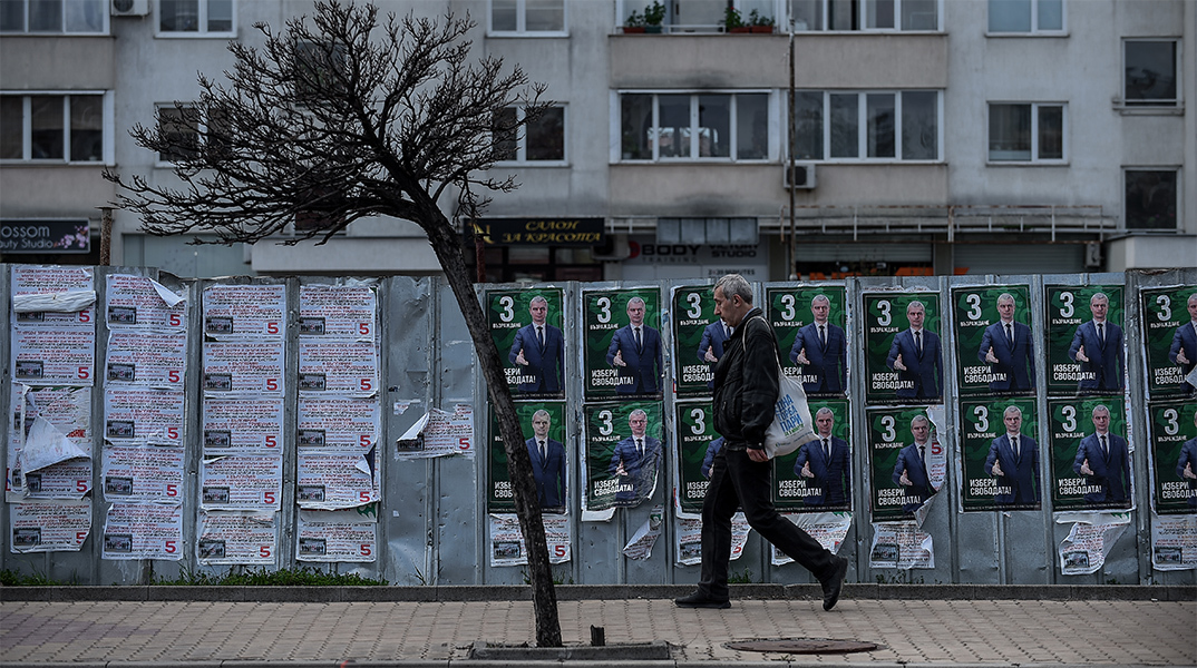 Βούλγαρος πολίτης περπατά μπροστά από προεκλογικές αφίσες υποψηφίου