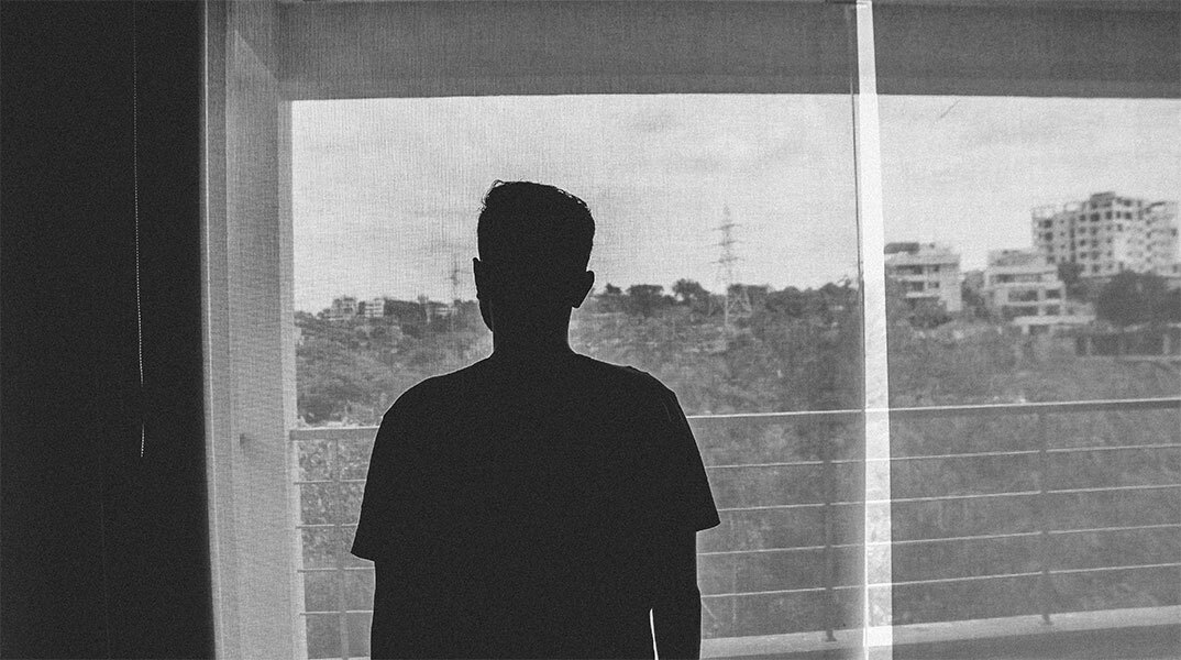 Έφηβος κοιτά από το παράθυρο