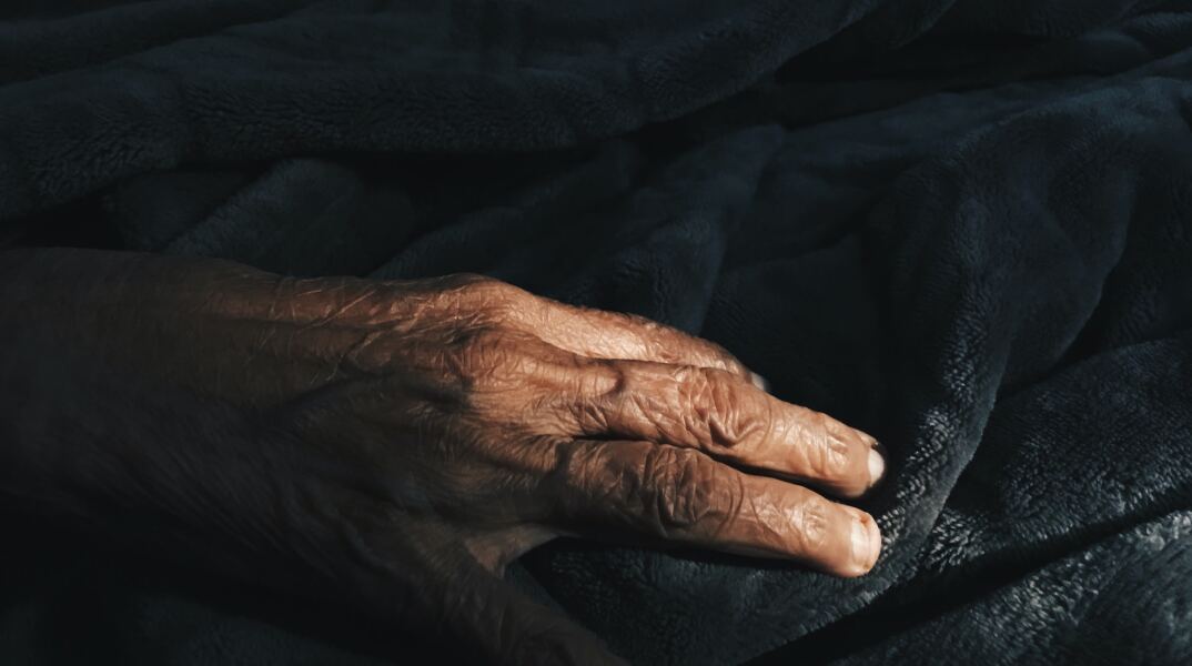 Χέρι ηλικιωμένου σε κλινοσκεπάσματα