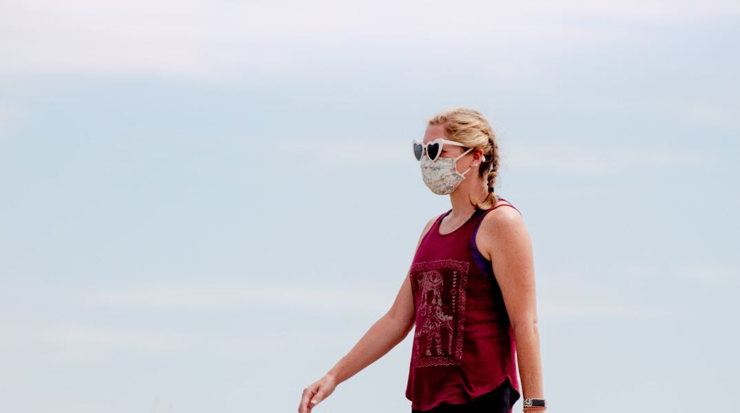 Γυναίκα περπατά με μάσκα σε περιοχή των ΗΠΑ