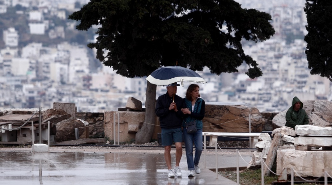 Ζευγάρι κάτω από την ομπρέλα προστατεύεται από τη βροχή