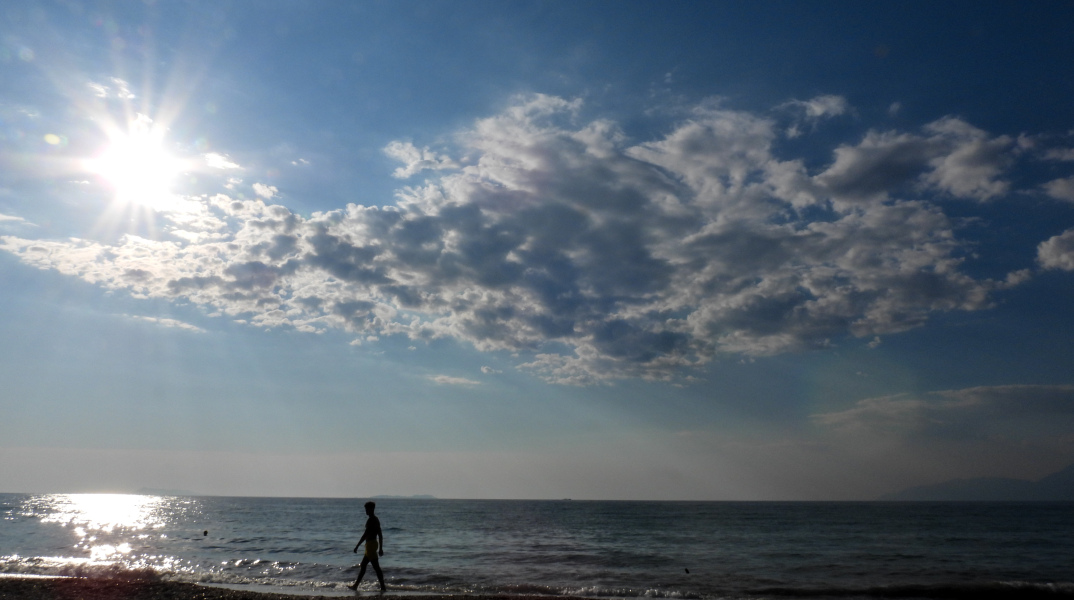 Βόλτα σε παραλία με ήλιο και λίγα σύννεφα