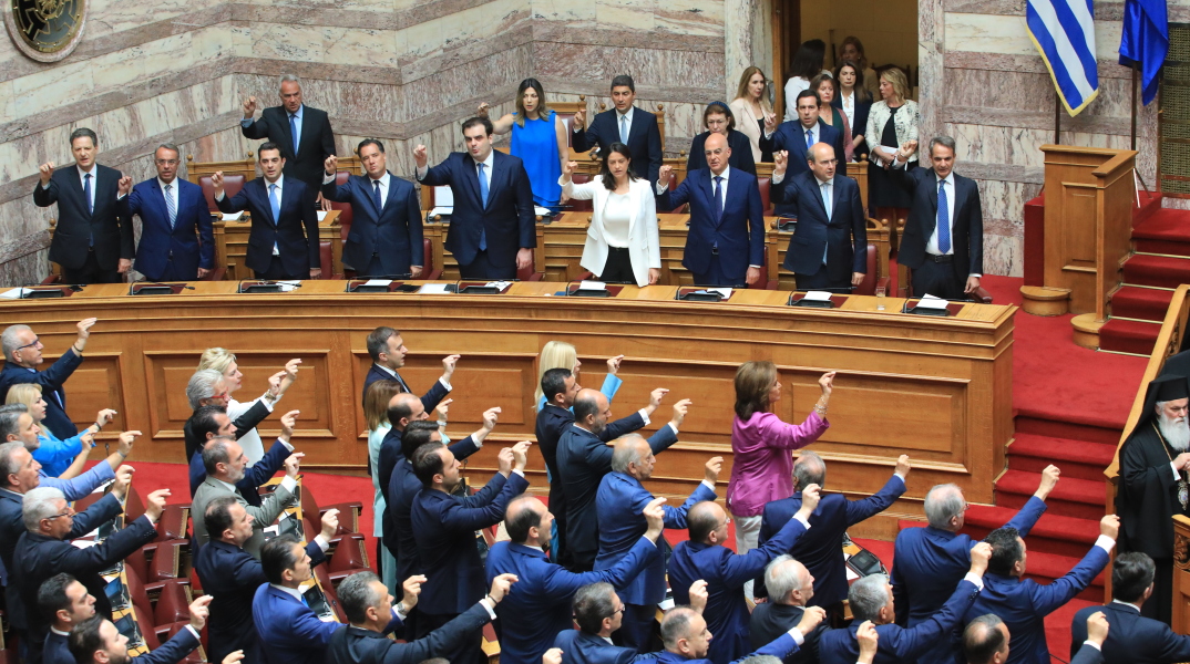 Όρθιοι στα έδρανα οι βουλευτές δίνουν τον θρησκευτικό όρκο υψώνοντας το δεξί τους χέρι