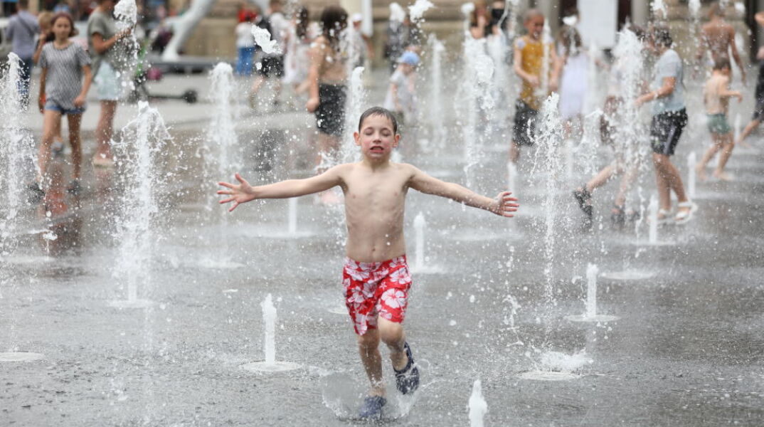 Παιδιά απολαμβάνουν τη δροσιά σε σιντριβάνι στην Ουκρανία
