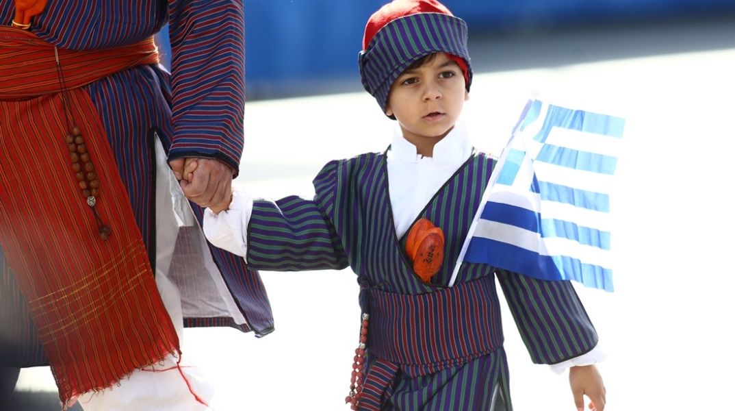 Παιδάκι με παραδοσιακή φορεσιά και την ελληνική σημαία στη στρατιωτική παρέλαση της Θεσσαλονίκης