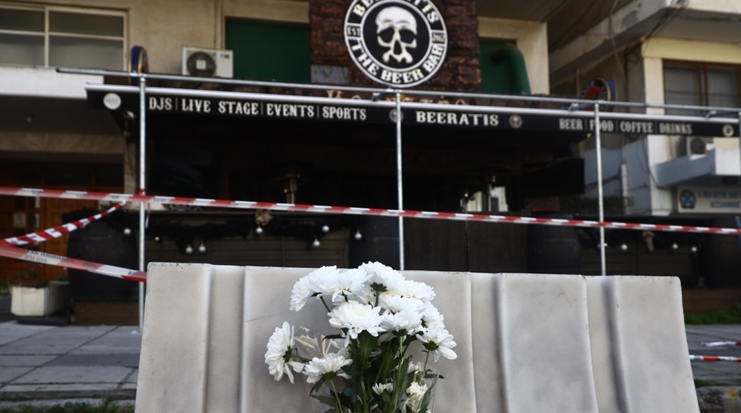 Λίγα λουλούδια έξω από το μπαρ όπου δολοφονήθηκε ο 32χρονος αστυνομικός στη Θεσσαλονίκη