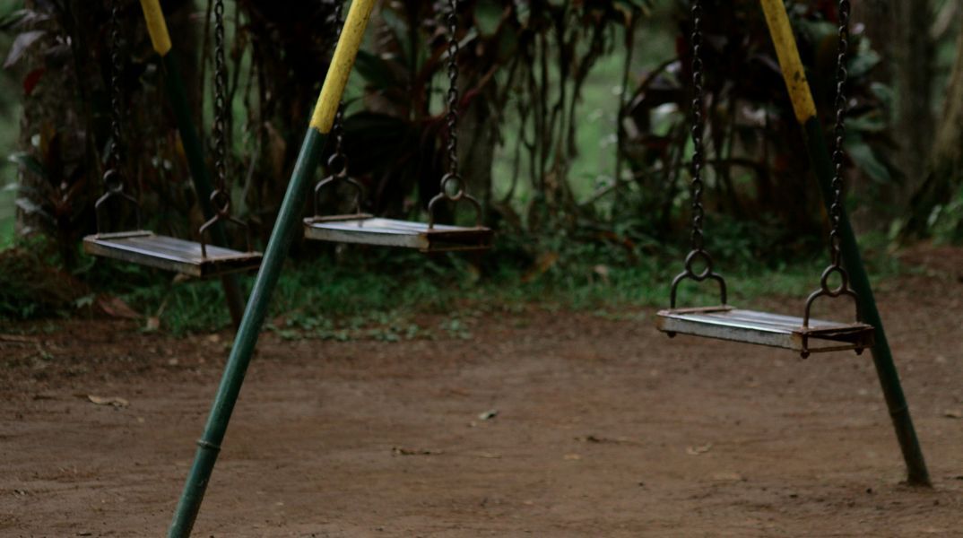 Τρεις άδειες κούνιες σε μια αυτοσχέδια παιδική χαρά, όπου θα μπορούσαν να παίζουν η Μαντλίν, ο Μπεν και ο Άλεξ