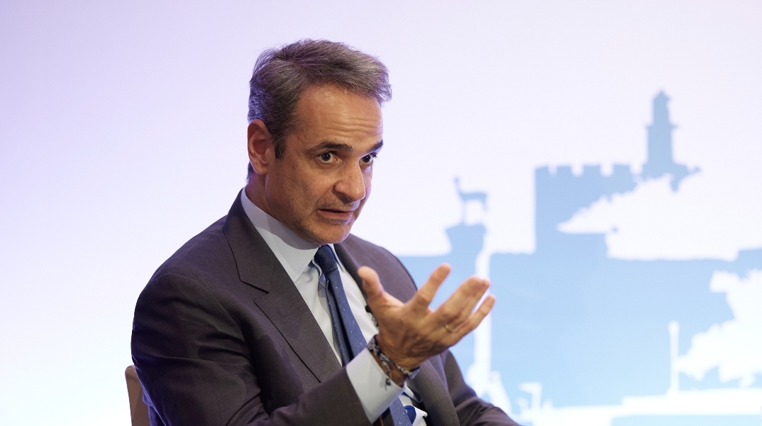 O Κυριάκος Μητσοτάκης μιλάει καθισμένος σε επίσκεψή του στη Ρόδο