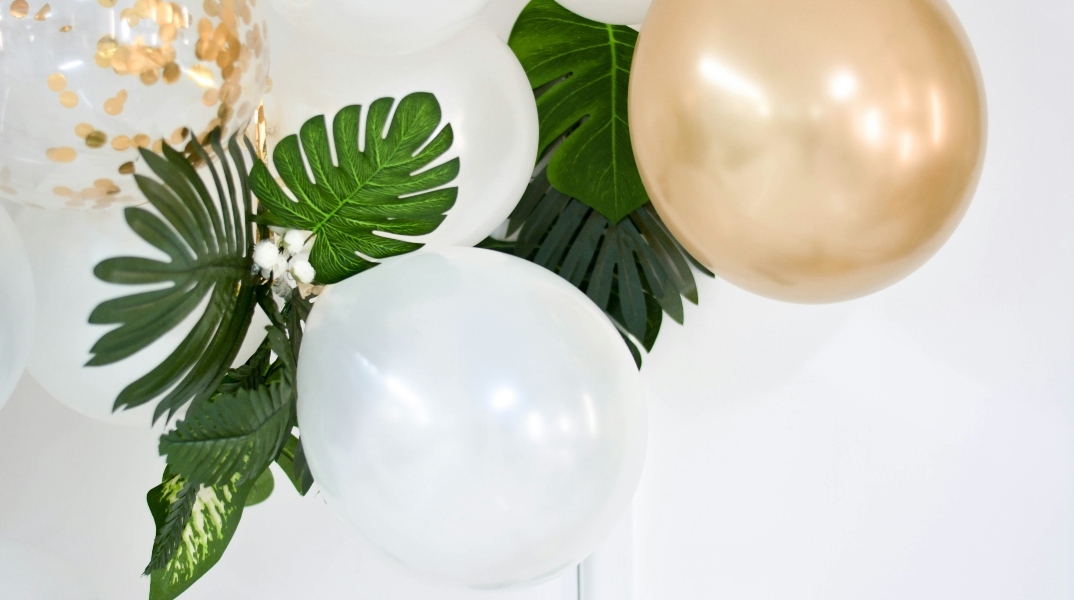 3 άσπρα μπαλόνι και ένα χρυσαφί μαζί με πράσινα φύλλα