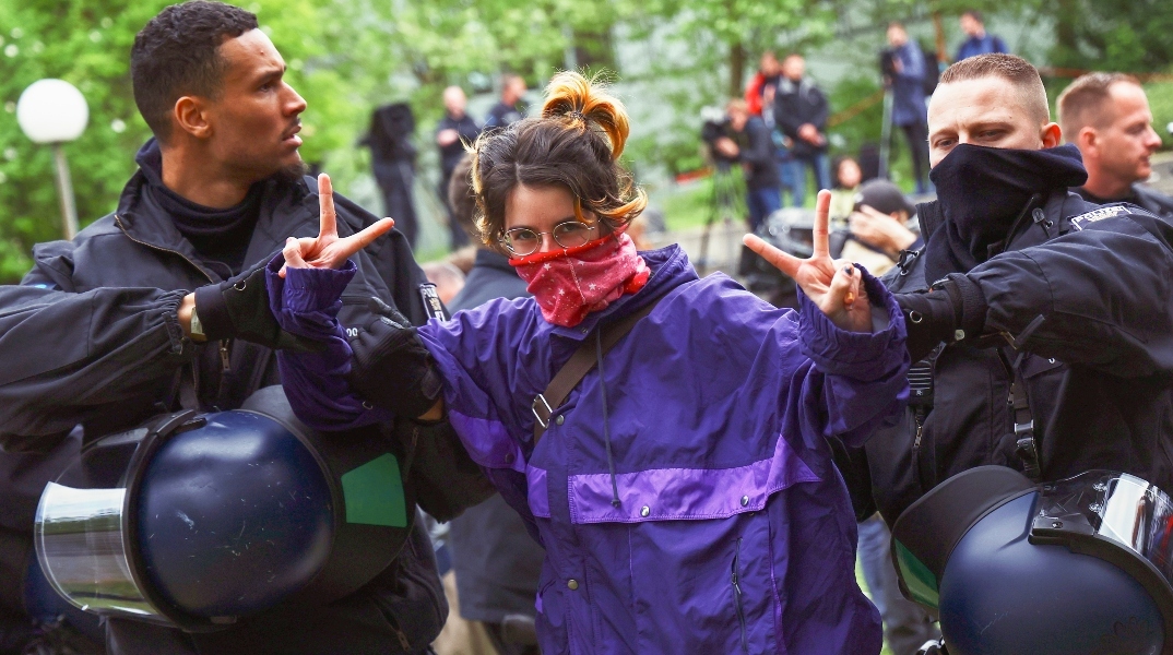 αστυνομικοί συλλαμβάνουν διαδηλώτρια