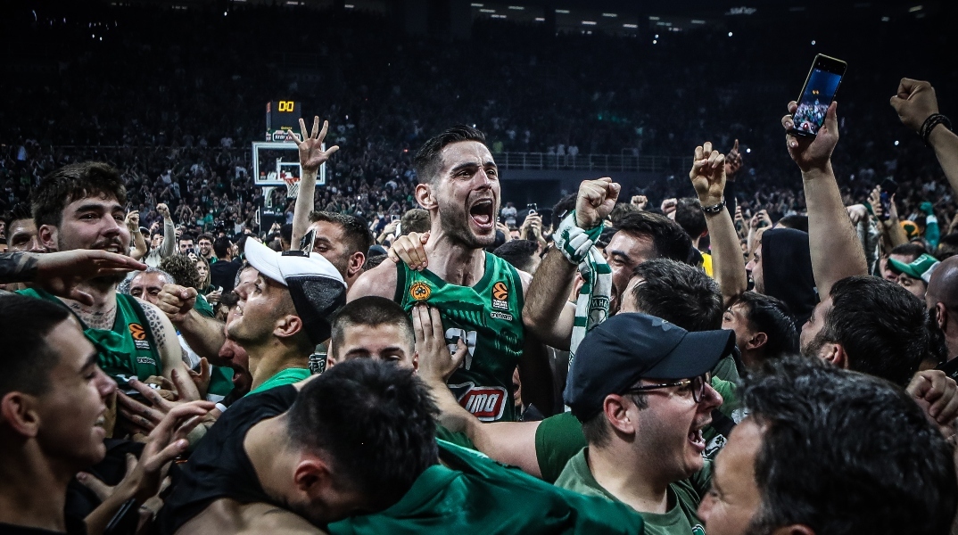 αθλητες και φιλαθλοι αγκαλιασμένοι στα πράσινα σε γήπεδο μπάσκετ