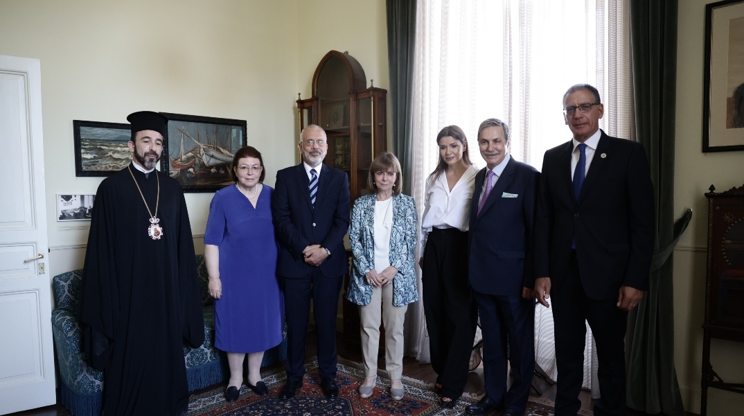 4 ανδρες, 3 γυναικες σε σπιτι, χαλί, πινακες, επιπλα