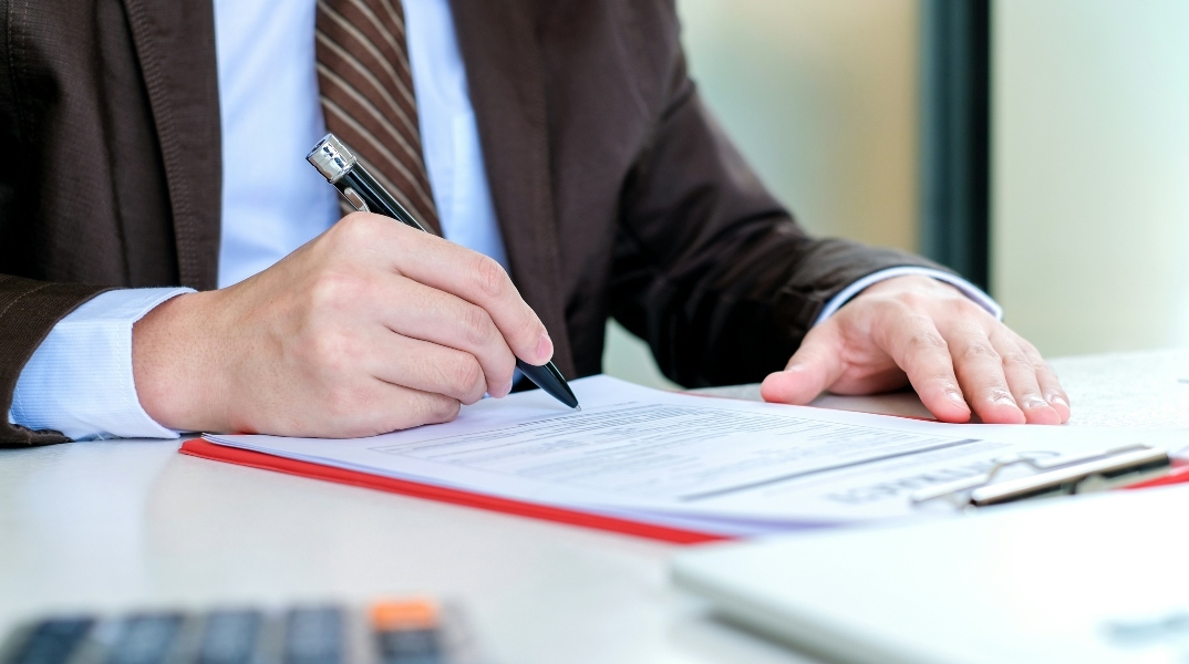 ανδρας συμπληρωνει αιτηση, στυλος