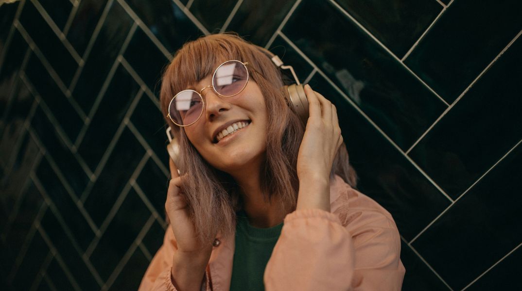 Μια νεαρή γυναίκα ακούει μουσική στα ακουστικά της