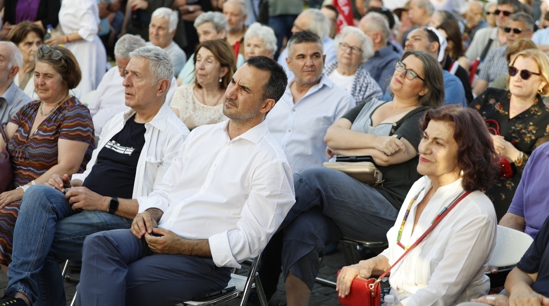 ο Αλέξη Χαρίτση καθισμενος αναμεσα σε κοσμο