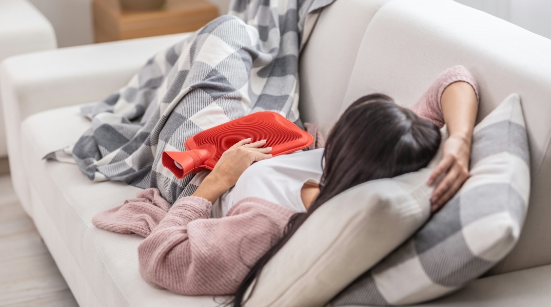 γυναικα ξαπλωμενη, καναπες, κουβερτα, κοκκινη θερμοφορα