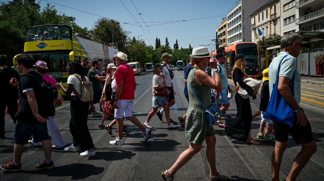 κοσμος διασχιζει δρομο στο κεντρο της Αθηνας