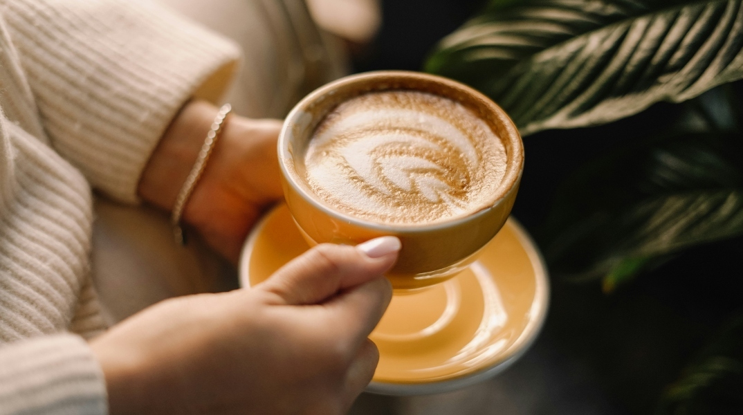 2 χερια κραταν φλυτζανι με καφε