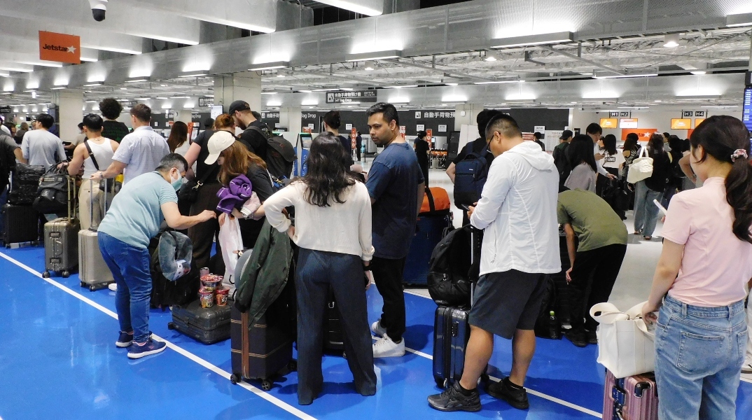 επιβατες περιμενουν στον ελεγχο αποσκευων αεροδρομιου