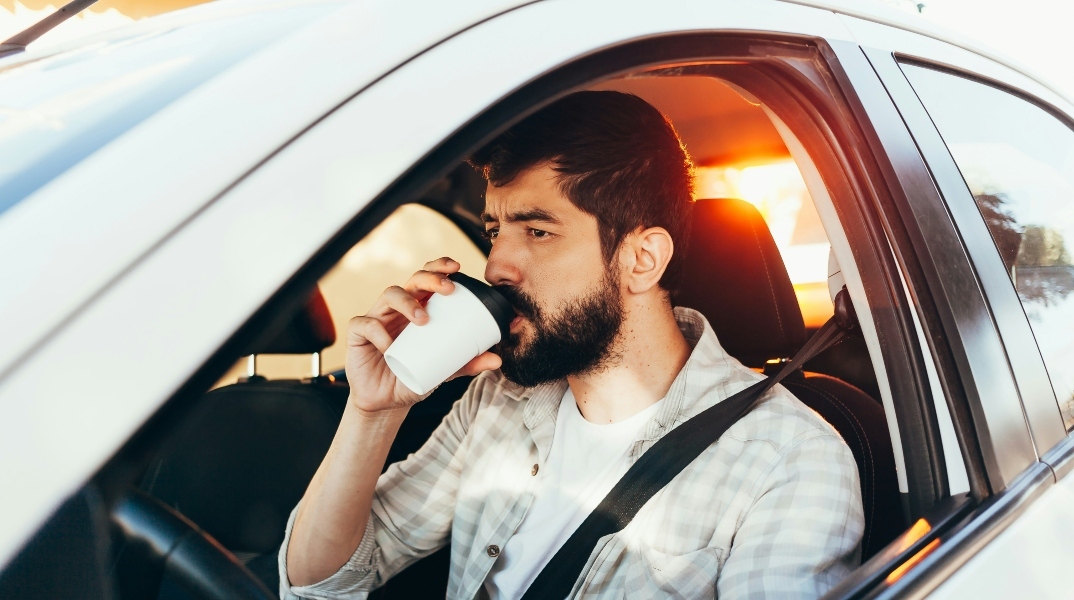 ανδρας πινει καφε μεσα σε αμαξι